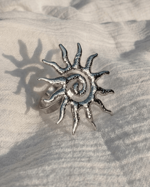Anello sole Giunquilla in acciaio placcato oro 18k con spirale, simbolo dei cicli naturali Anello Soleya Giunquilla a forma di sole con spirale puntinata, energia solare e femminile Anello Giunquilla con sole e spirale in oro 18k, geometria sacra ispirata a Newgrange e alle Ande Anello sole Giunquilla in acciaio dorato, per portare energia solare sacra in ogni gesto quotidiano Anello Soleya Giunquilla: spirale e sole in oro 18k, movimento ciclico del femminile al dito