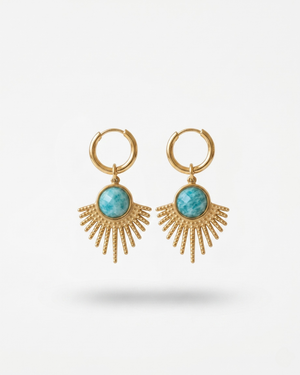 Orecchini Sevilla Giunquilla in oro 18k con eliolite, pietra del sole e luminosità Orecchini dorati Giunquilla con amazzonite, energia di espressione autentica e protezione Orecchini Giunquilla a raggi in acciaio placcato oro 18k con eliolite verde su sfondo naturale Orecchini Sevilla Giunquilla con amazzonite, per donne che occupano spazio con gioia Orecchini pendenti Giunquilla con pietra del sole, stile boho chic ispirato al folklore andaluso