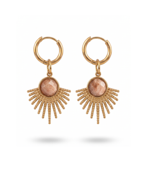 Orecchini Sevilla Giunquilla in oro 18k con eliolite, pietra del sole e luminosità Orecchini dorati Giunquilla con amazzonite, energia di espressione autentica e protezione Orecchini Giunquilla a raggi in acciaio placcato oro 18k con eliolite verde su sfondo naturale Orecchini Sevilla Giunquilla con amazzonite, per donne che occupano spazio con gioia Orecchini pendenti Giunquilla con pietra del sole, stile boho chic ispirato al folklore andaluso