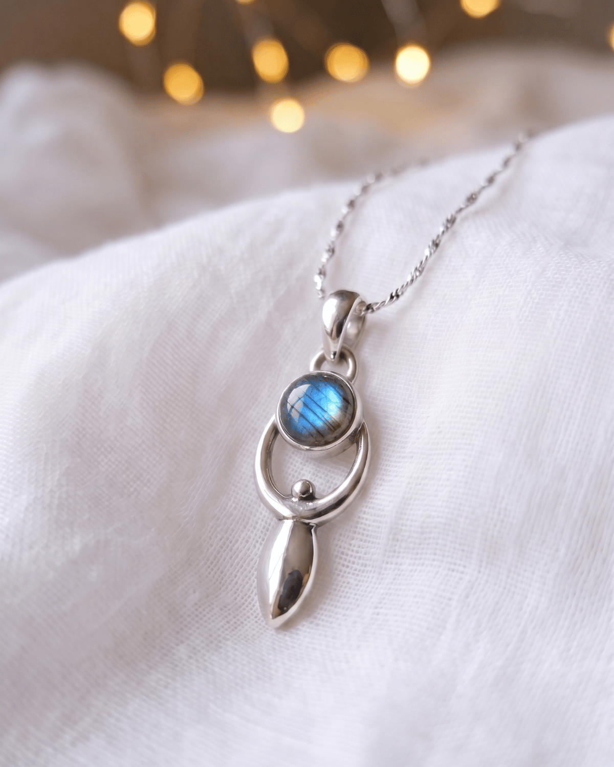 Ciondolo Goddess Giunquilla in argento 925 con labradorite bianca, archetipo della dea vicino al cuore Ciondolo Giunquilla con diaspro rosso in argento 925, creatività femminile e connessione con la terra Ciondolo Goddess Giunquilla argento 925 e pietra di luna arcobaleno, energia del divino femminile Ciondolo Giunquilla con forma della dea, labradorite bianca e simbolismo del ciclo mestruale Ciondolo Goddess Giunquilla in argento 925, gioiello spirituale per chi onora la forza divina della donna
