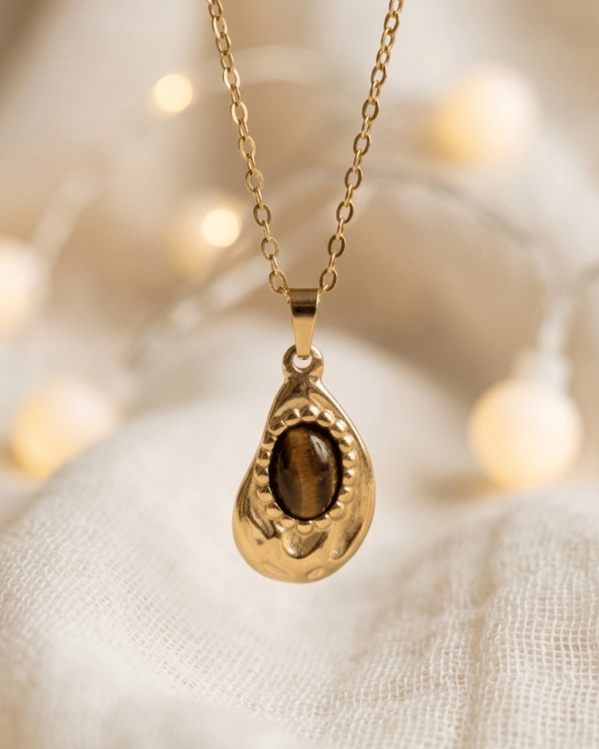 Collana Gotita Giunquilla in oro 18k con occhio di tigre, amuleto di protezione e forza Ciondolo Gotita Giunquilla con occhio di tigre, pietra del discernimento e della determinazione Collana pendente in acciaio placcato oro Giunquilla con occhio di tigre, stile retrò e sacro femminile Ciondolo Giunquilla con occhio di tigre su catena dorata, energia di radicamento e volontà Collana Gotita Giunquilla, oro 18k e occhio di tigre: un amuleto antico per la donna contemporanea
