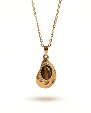 Collana Gotita Giunquilla in oro 18k con occhio di tigre, amuleto di protezione e forza Ciondolo Gotita Giunquilla con occhio di tigre, pietra del discernimento e della determinazione Collana pendente in acciaio placcato oro Giunquilla con occhio di tigre, stile retrò e sacro femminile Ciondolo Giunquilla con occhio di tigre su catena dorata, energia di radicamento e volontà Collana Gotita Giunquilla, oro 18k e occhio di tigre: un amuleto antico per la donna contemporanea
