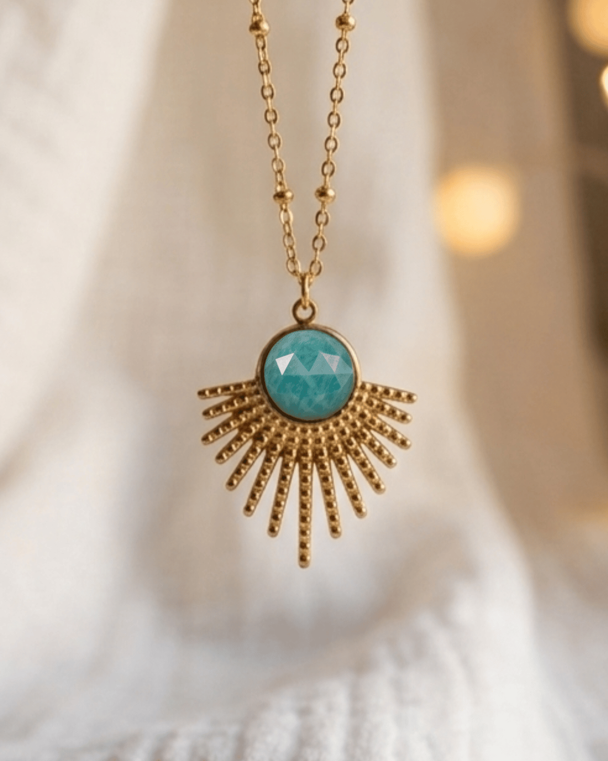 Collana Sevilla Giunquilla in acciaio placcato oro 18k con eliolite, pietra del sole Ciondolo Sevilla Giunquilla con amazzonite, pietra della comunicazione e dell'espressione spontanea Collana dorata Giunquilla con eliolite e raggi solari, simbolo di luminosità e gioia vitale Ciondolo in oro 18k Giunquilla con amazzonite verde, energia solare e protezione della sensibilità Collana Sevilla Giunquilla, acciaio placcato oro con pietra del sole e forma a raggi ispirata a Siviglia
