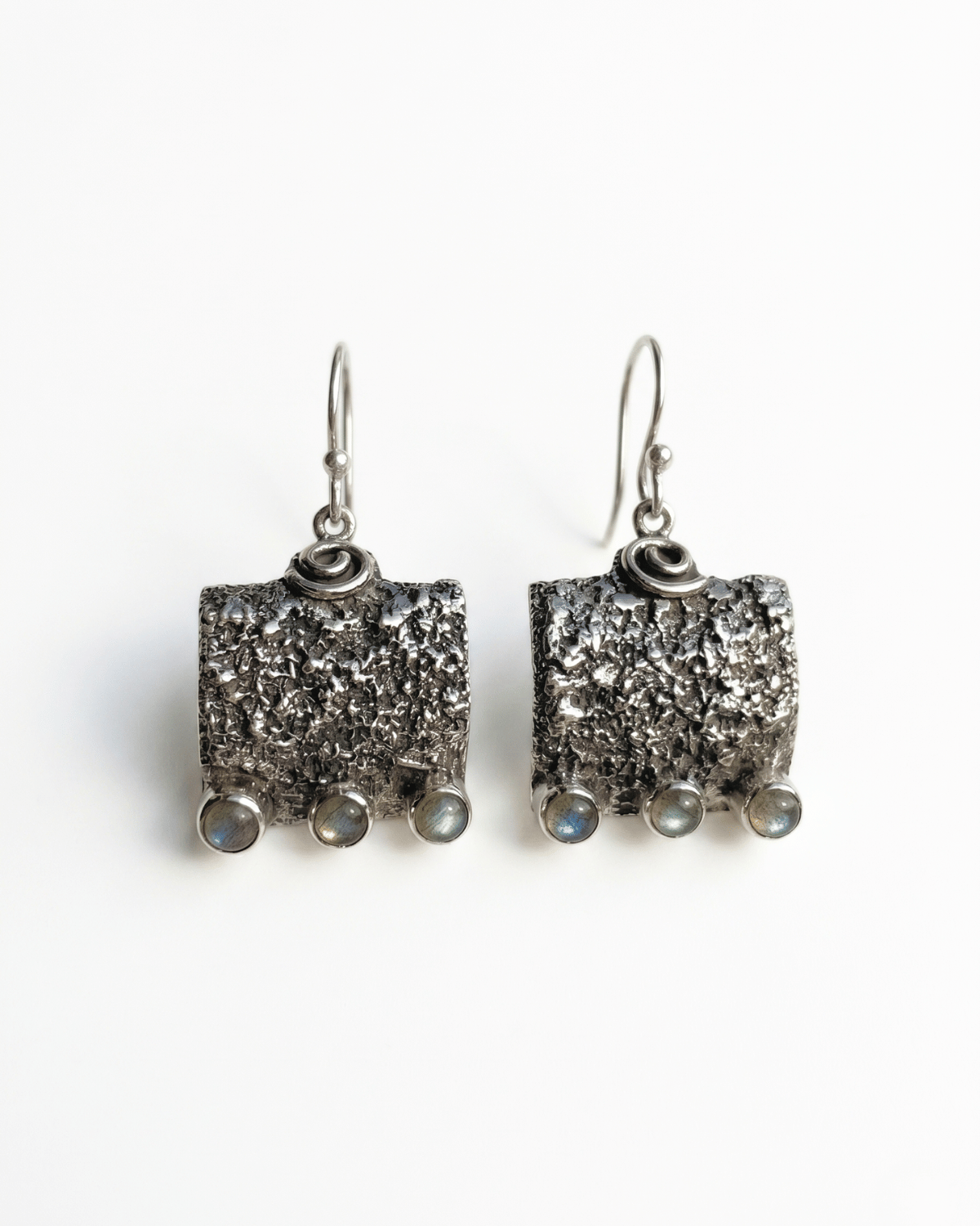 Orecchini pendenti Wayra Giunquilla in argento 925 con labradorite, equilibrio tra terra e luna Orecchini Giunquilla con labradorite cangiante in argento 925, radicamento e flusso ciclico femminile Orecchini quadrati pendenti Giunquilla in argento con labradorite e spirale, simboli del cosmo Orecchini Wayra Giunquilla argento 925 e labradorite: energia terrestre e ritmo interiore al lobo Orecchini pendenti Giunquilla con labradorite in argento 925, gioiello spirituale del sacro femminile
